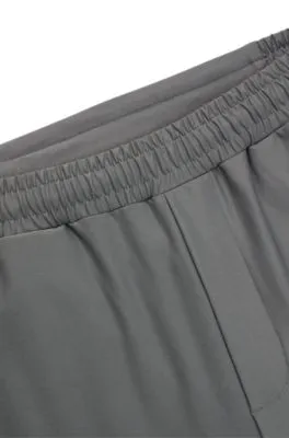 Pantalones de chándal en tejido elástico con logo reflectante decorativo