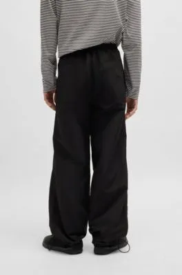 Pantalones relaxed fit con pliegues dobles en la rodilla